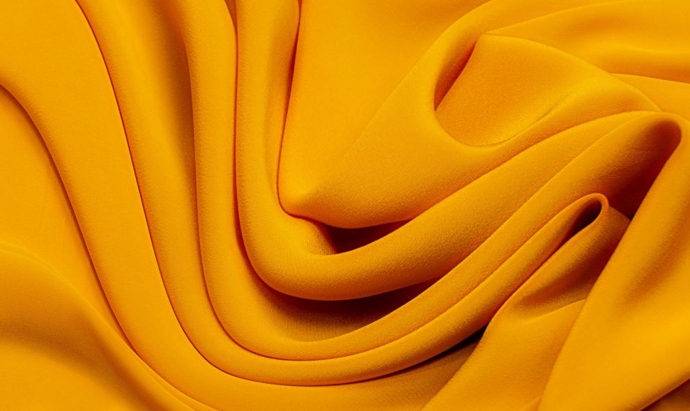 Texture, background, pattern. Texture of yellow or golden silk or cotton or wool fabric. Beautiful pattern of fabric.